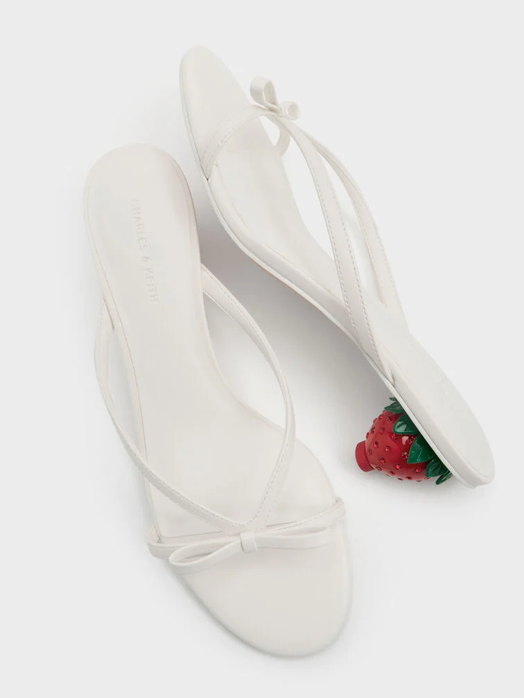 White bow-embellished mules with strawberry-shaped heels, ideal for everyday wear. 