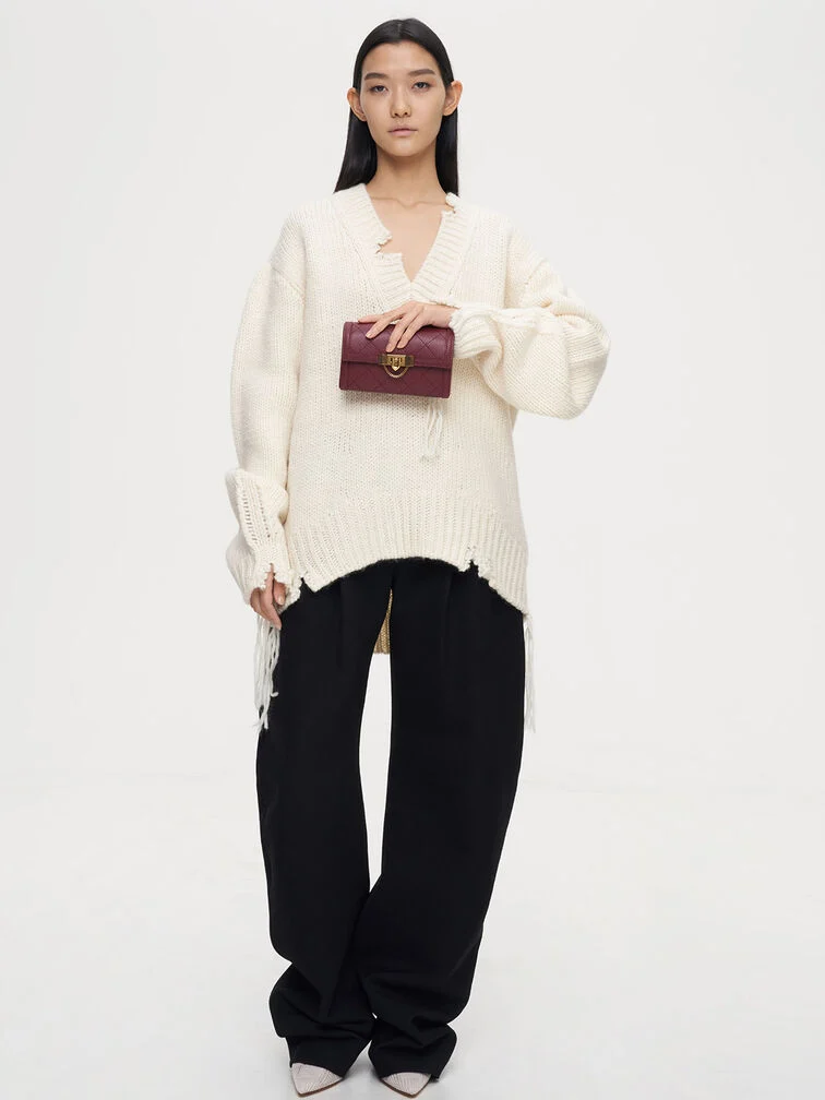 Clutch yang digenggam dari atas dengan jari-jari melengkung ke bagian depan, cara memegang yang santai namun elegan untuk acara formal.