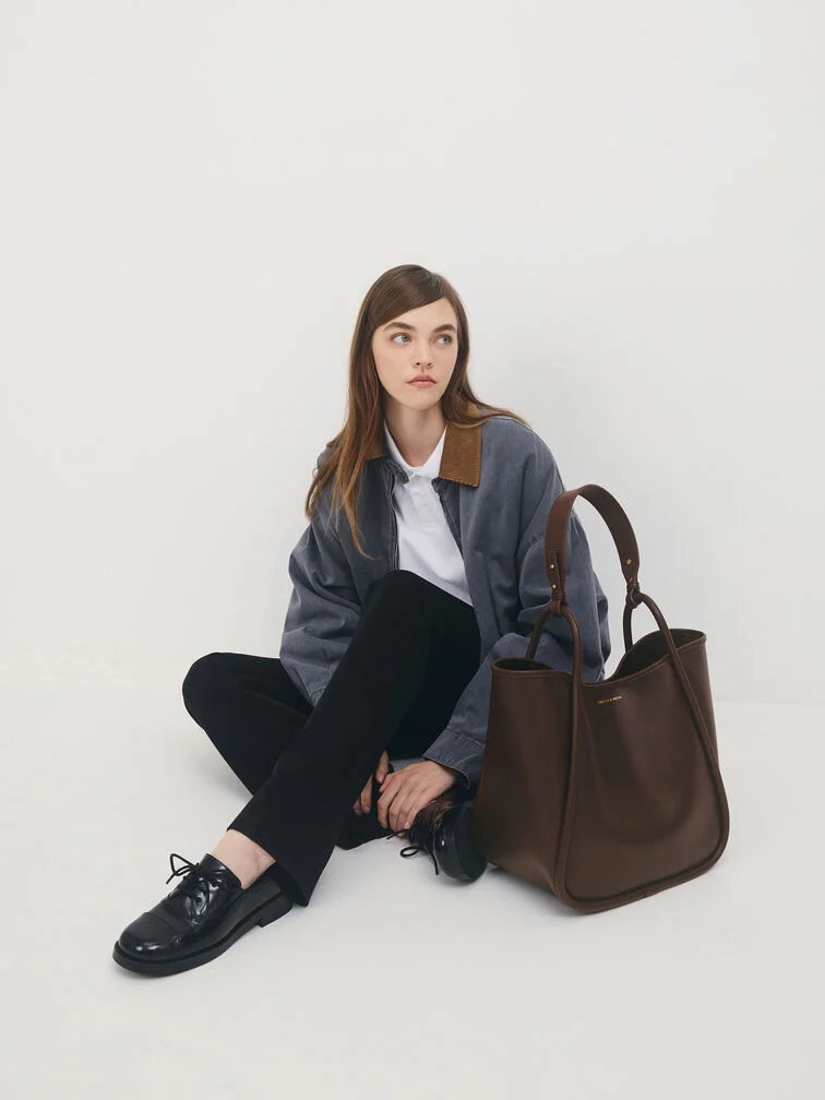 The Lyla tote paired with a jacket, derby shoes and a white button-up shirt.