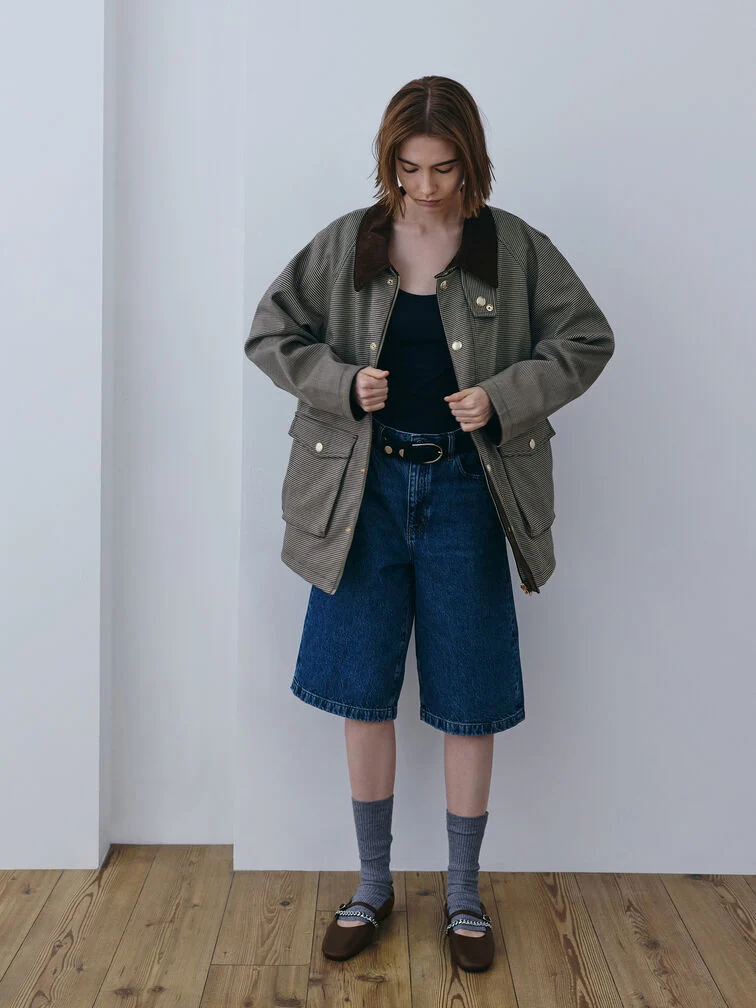 An oversized jacket layered over a casual top-and-jorts ensemble.